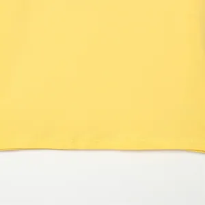 Primer plano del dobladillo de doble costura de una camiseta de algodón amarillo