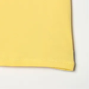Primer plano del dobladillo de la camiseta amarilla con costura de doble aguja de calidad