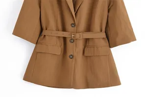 Detailed macro view of a brown belted women's blazer featuring buttons and flap pockets