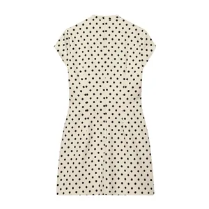 Vue arrière détaillée d'une élégante robe courte blanche à pois noirs avec fermeture éclair