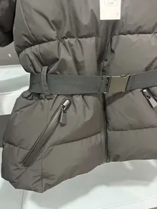 Detailed view of a black belted puffer jacket with diagonal side zipper pockets.