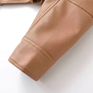 Détail de la manche d'une veste de moto en cuir marron avec une texture de couture.