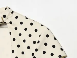 Détail de la robe crème à pois montrant la texture du tissu et la construction du col