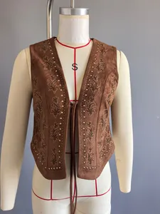 Gros plan du gilet en daim marron rétro avec clous métalliques et broderies florales