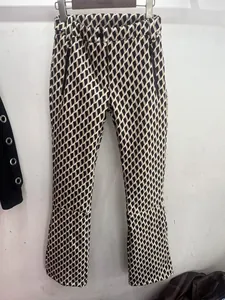 Detailed view of women's ski pants with geometric rhombus pattern and zip pockets.