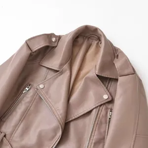 Détail d'une veste de motard vintage en similicuir taupe avec fermetures éclair.