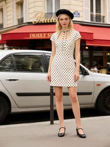 Robe courte élégante à pois beiges avec col à nœud papillon et découpe sur le devant