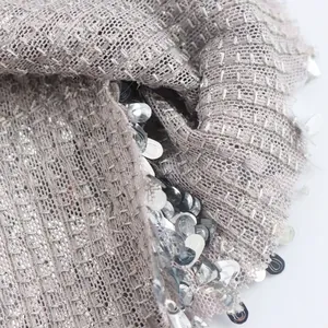 Detalle de cerca de tela texturizada con lentejuelas plateadas en un vestido elegante