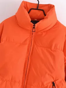 Close-up of orange puffer jacket featuring a high collar and sturdy front zipper detail.