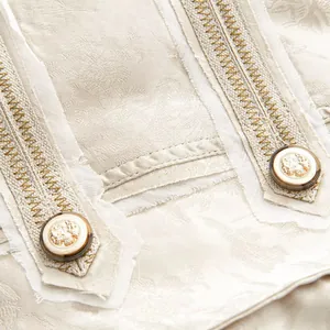 Detailansicht des Vintage-Jacquard-Stoffes und der geprägten Goldknöpfe am Blazer