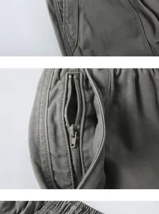 Detaillierte Nahaufnahme der Metallreißverschlusstasche an olivgrünen Cargo-Shorts