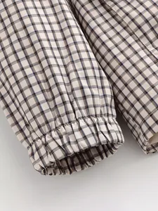 Détail rapproché des poignets élastiques d'une veste à carreaux vintage texturée