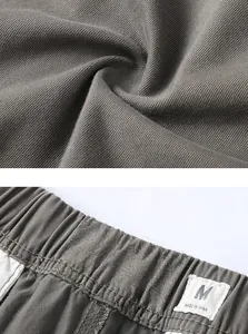Detail of cotton cargo shorts showing twill fabric texture and elastic waistband with size tag.