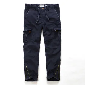Vintage navy blue men's cargo pants in washed cotton with multi-pockets and leg zippers.
