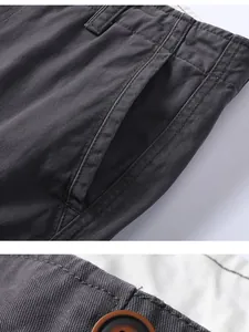 Close-up detail of men's cotton cargo shorts showing pocket stitching and button