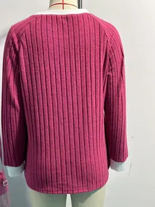 Vista posteriore dettagliata di un maglione a coste rosa con scollo e polsini bianchi a contrasto