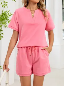 Detalle del conjunto rosa con top con cuello en V y pantalones cortos con cordón