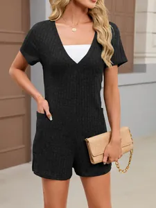 Close-up of women's summer black ribbed knit short sleeve romper with front pockets