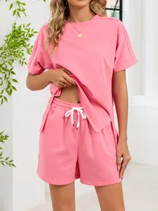 Casual pink two-piece set with side-slit t-shirt and drawstring shorts for women.