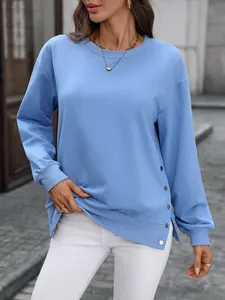 Detail des hellblauen Sweatshirts mit Seitenschlitz und dekorativen Silberknöpfen