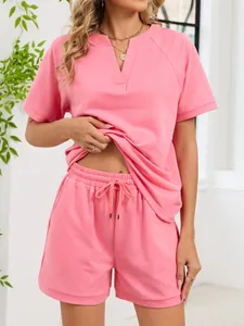 Detalle del conjunto rosa de camiseta con cuello en V y pantalones cortos con cordón