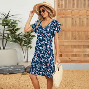 Close-up of a navy blue floral V-neck dress with double ruffle sleeves on a model