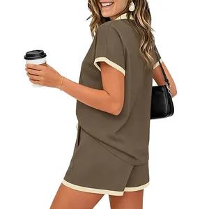Seitenansicht einer Frau in einem olivgrünen zweiteiligen Shorts-Set mit cremefarbenem Rand