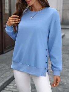 Detailansicht eines hellblauen Sweatshirts mit modischen seitlichen Knopfschlitzen