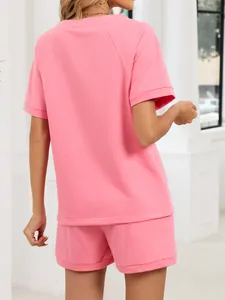 Vista posterior de un conjunto casual rosa de camiseta de manga corta y pantalones