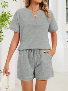 Detalle del conjunto informal de camiseta gris con cuello en V y pantalones cortos