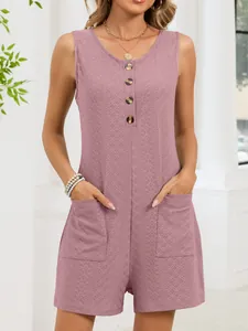Dettaglio di una tutina senza maniche color malva con bottoni, tasche e tessuto operato