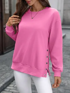 Detailansicht eines pinkfarbenen Sweatshirts mit Seitenknöpfen und Schlitz am Saum