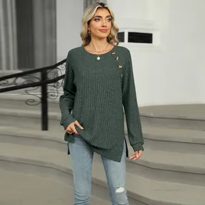 Détail d'un haut en tricot vert avec boutons à l'épaule et fente latérale