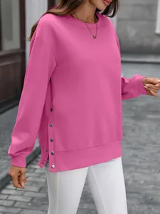 Detailansicht eines rosa Sweatshirts mit Rundhalsausschnitt und silbernen Knöpfen am Saum.