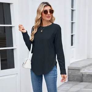Detailed view of women's black long sleeve top with textured diamond knit pattern.