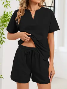 Vista de detalle de conjunto negro de dos piezas con top de cuello V y pantalón corto