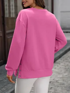 Detailansicht eines rosa Sweatshirts mit Rundhalsausschnitt und seitlichem Schlitz
