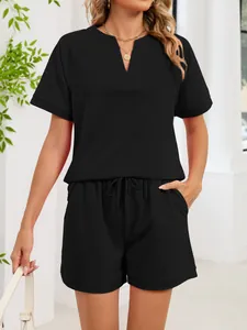 Vista detallada de un conjunto negro con camiseta de cuello en V y pantalones cortos