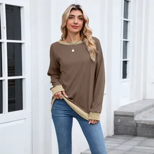 Détail d'un sweat-shirt ample pour femme avec bord-côte contrasté et col rond.
