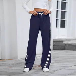 Détail du pantalon de jogging bleu marine à jambes larges et rayures latérales
