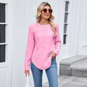 Detailed look at a pink long sleeve top with textured knit and a curved hemline.