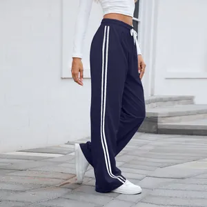 Détail rapproché des doubles bandes latérales blanches sur un pantalon de jogging large