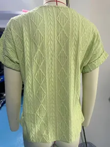 Detailed macro view showing the light green cable knit and diamond jacquard pattern