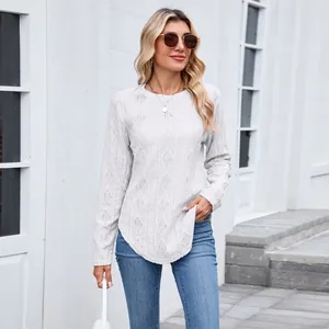 Detailed shot of woman wearing white diamond knit long sleeve top with curved hem