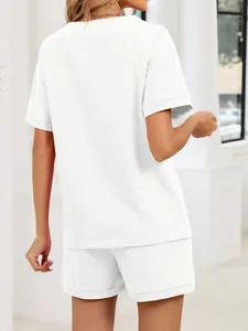 Vista trasera de un conjunto de camiseta y pantalón corto blanco para mujer en salón.