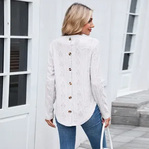 Detailed back view of white hollow-out knit top with decorative buttons and curved hem.