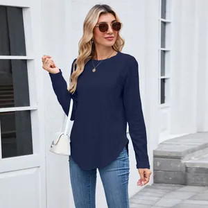Detail view of the textured hollow-out pattern and curved hem on a navy long sleeve top