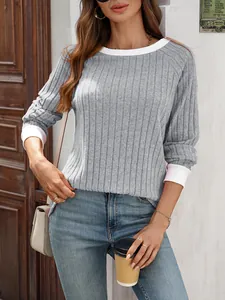 Dettaglio di un maglione grigio a coste con girocollo e polsini bianchi a contrasto