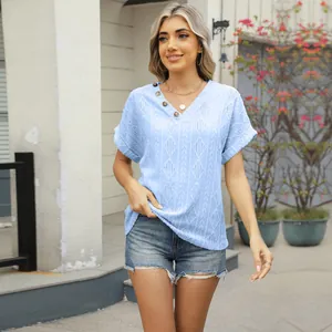 Outdoor full-body view of a model wearing a light blue V-neck knitted short sleeve top