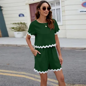 Detailed look at the dark green two-piece set featuring elegant scalloped white trim